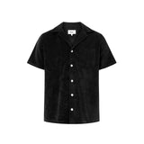 A short-sleeved black polo shirt with a relaxed fit and open collar, featuring pearl buttons and a single chest pocket.