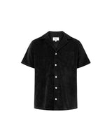 A short-sleeved black polo shirt with a relaxed fit and open collar, featuring pearl buttons and a single chest pocket.
