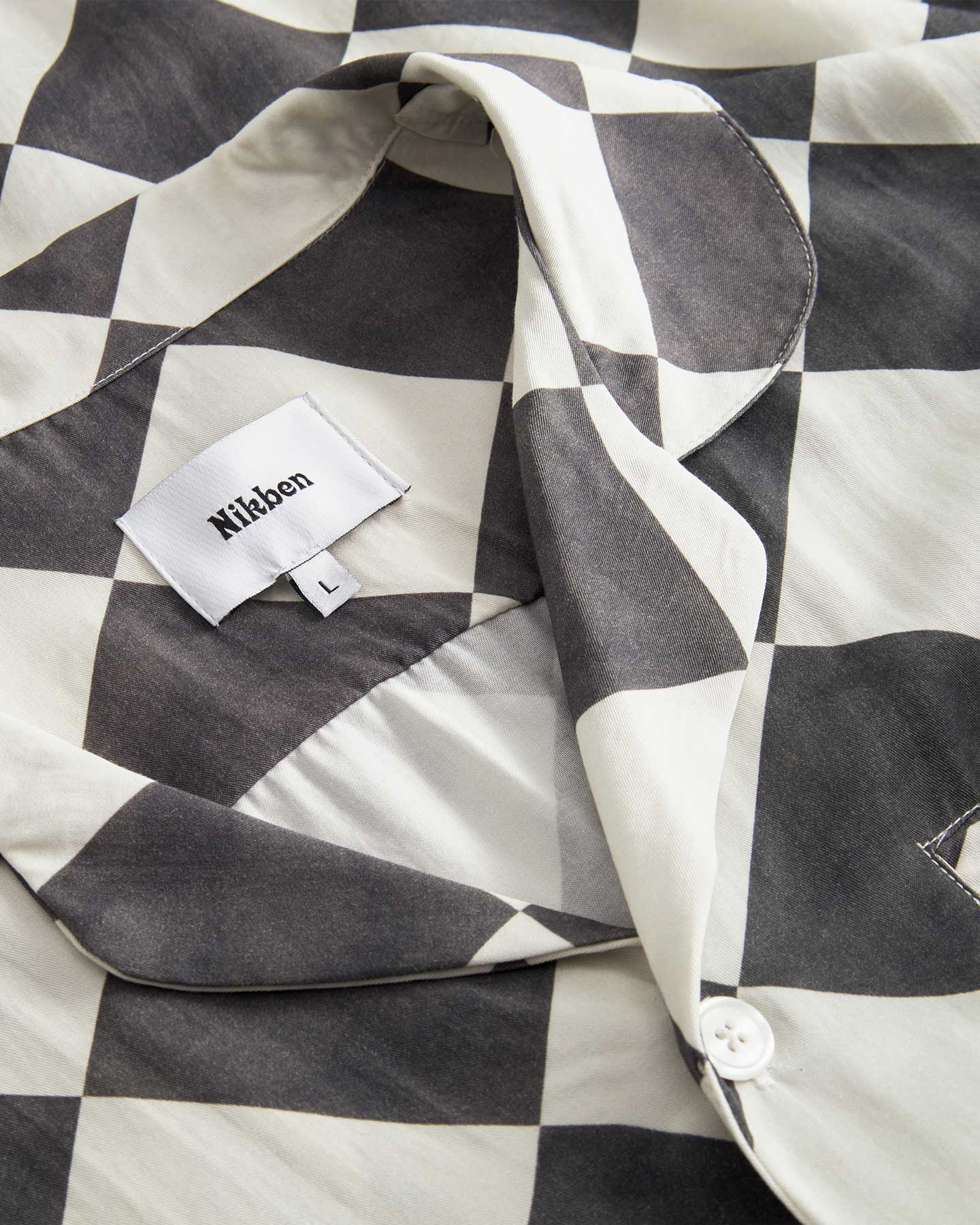 Collar and button on a Black and White chess pattern long sleeved shirt