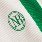 Close up of NB embroidery on white and green corduroy track suit pants