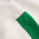 Close up of white and green corduroy track suit pants with NB embroidery