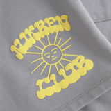 Close up of yellow Nikben Sunshine Club print on grey sweat shorts