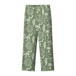 A pair of green pants with a multicolor graphic pattern, including geometric shapes and plant-like designs.