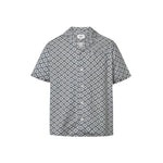 A short-sleeved steel blue shirt with a multicolor geometric pattern, an open collar, and button closure at the front.