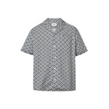A short-sleeved steel blue shirt with a multicolor geometric pattern, an open collar, and button closure at the front.