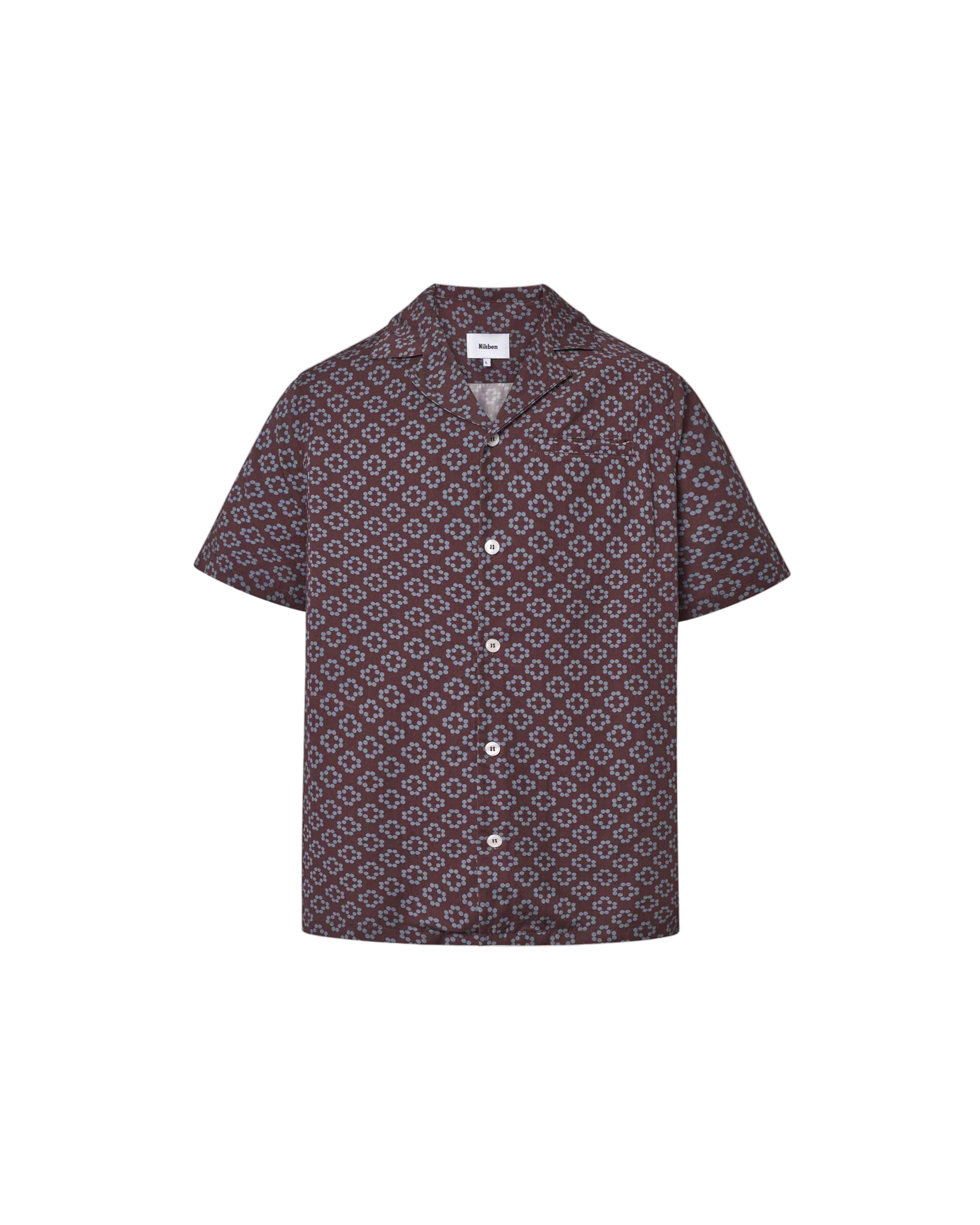 A short-sleeved brown shirt with a multicolor geometric pattern, an open collar, and button closures at the front.