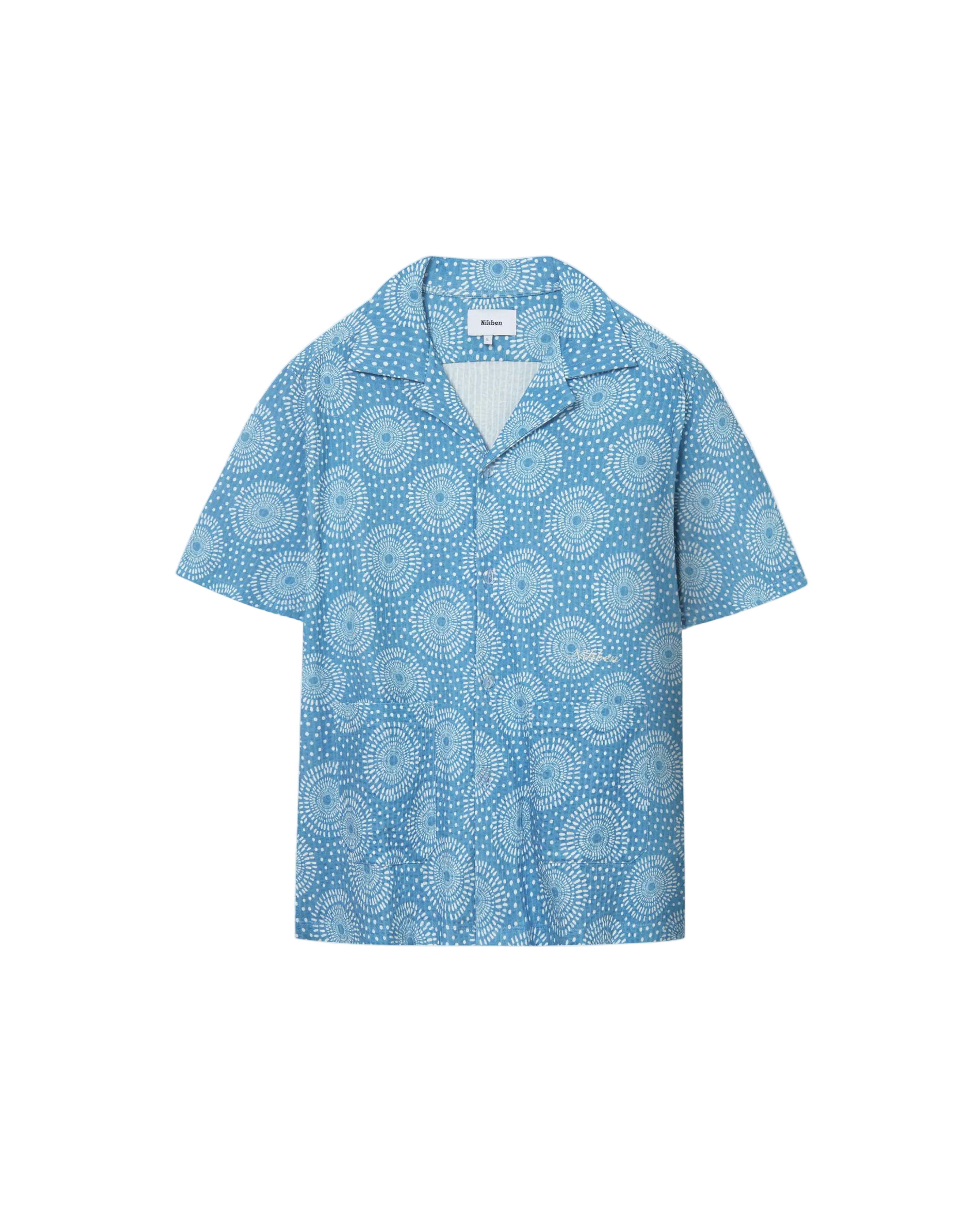 A short-sleeved blue shirt with a geometric pattern and mother-of-pearl buttons, displayed against a white background.