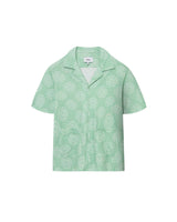 A short-sleeved green shirt with a camp collar and mother-of-pearl buttons, displayed against a plain background.
