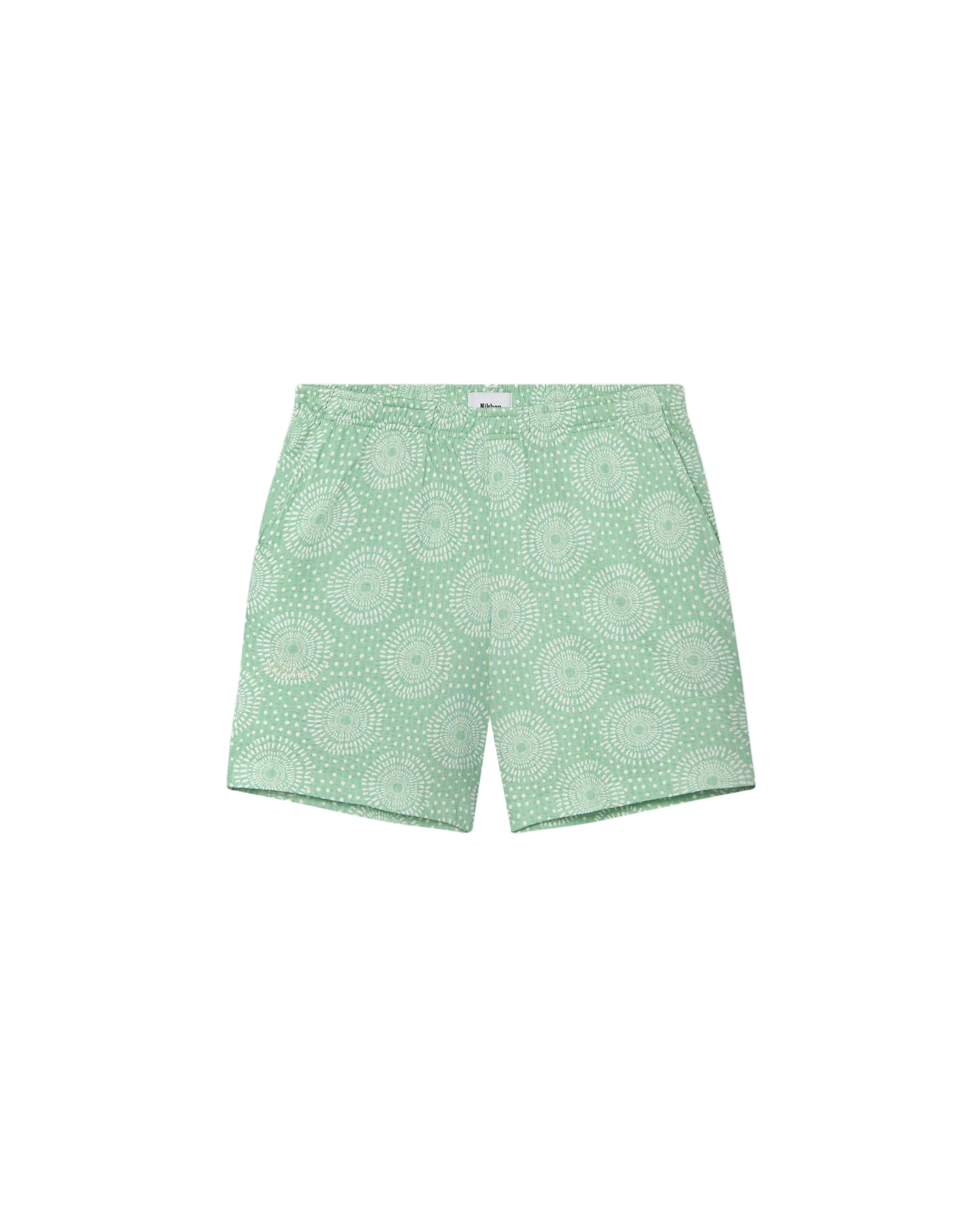 A pair of green Prainha shorts with a geometric pattern, crafted from 100% seersucker cotton.