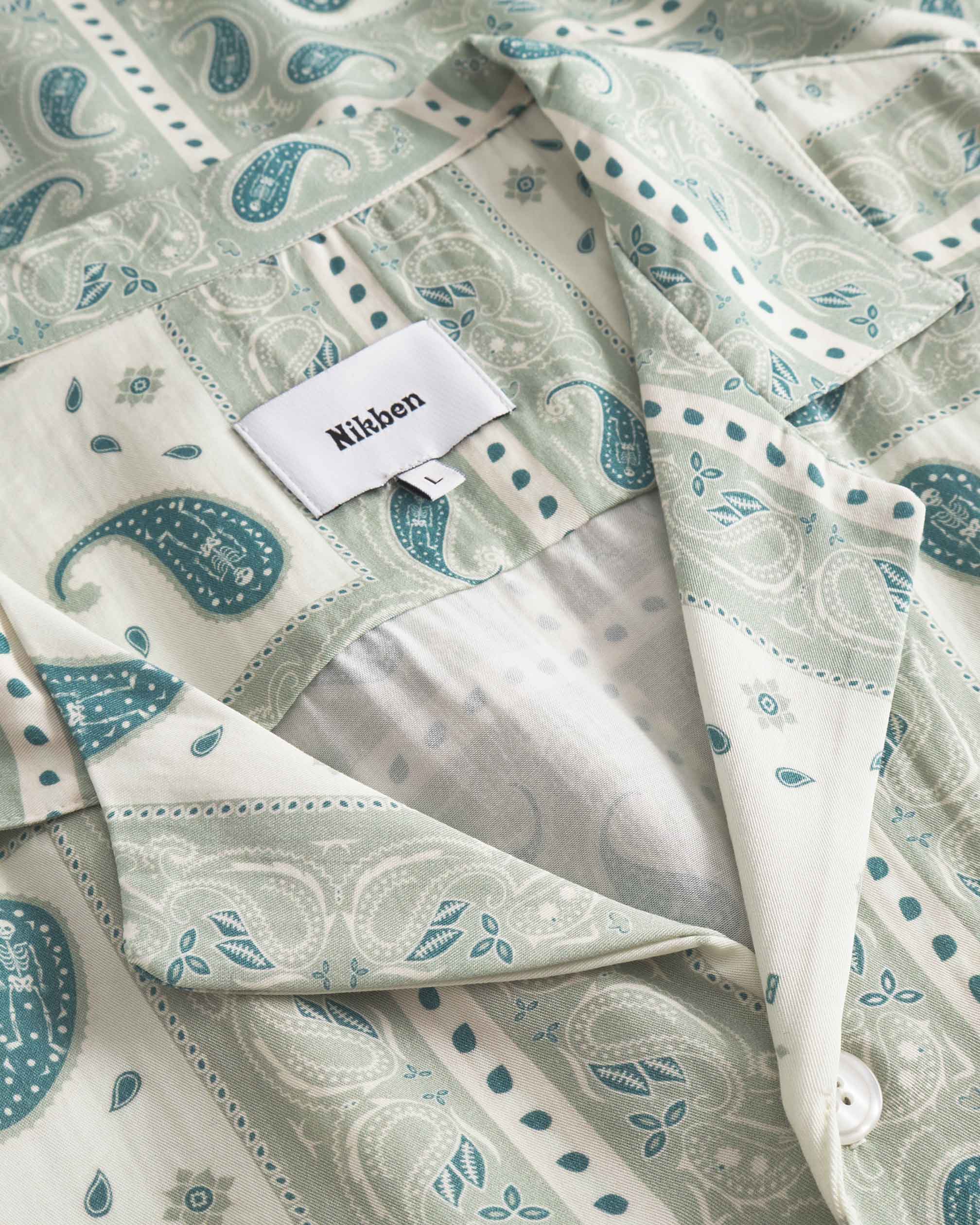 Close up on collar on a Vintage pale yellow short sleeved shirt with paisley pattern