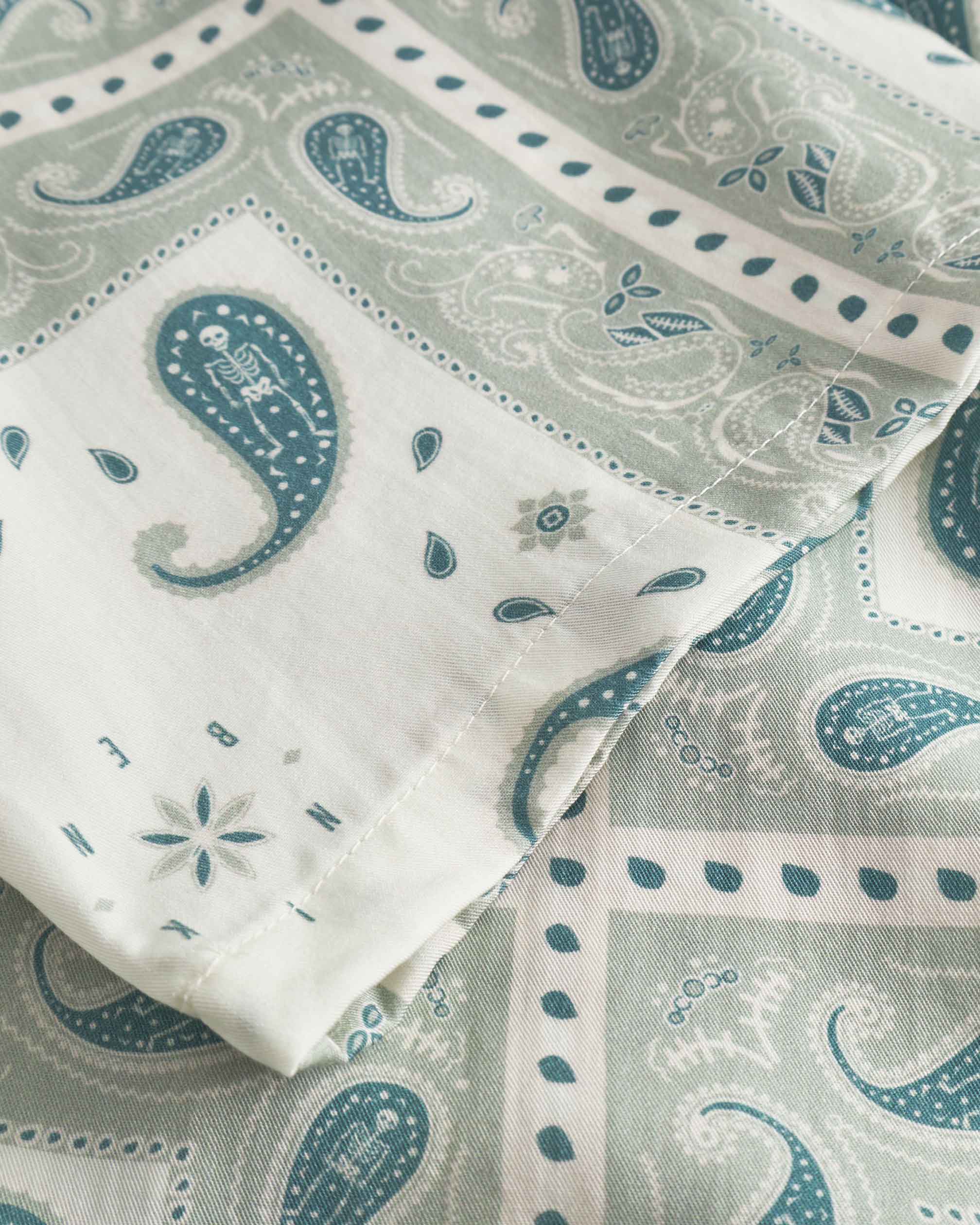 Close up on sleeve on a Vintage pale yellow short sleeved shirt with paisley pattern
