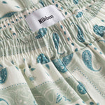 Close up of waist on a pair of vintage pale yellow paisley pattern long pants