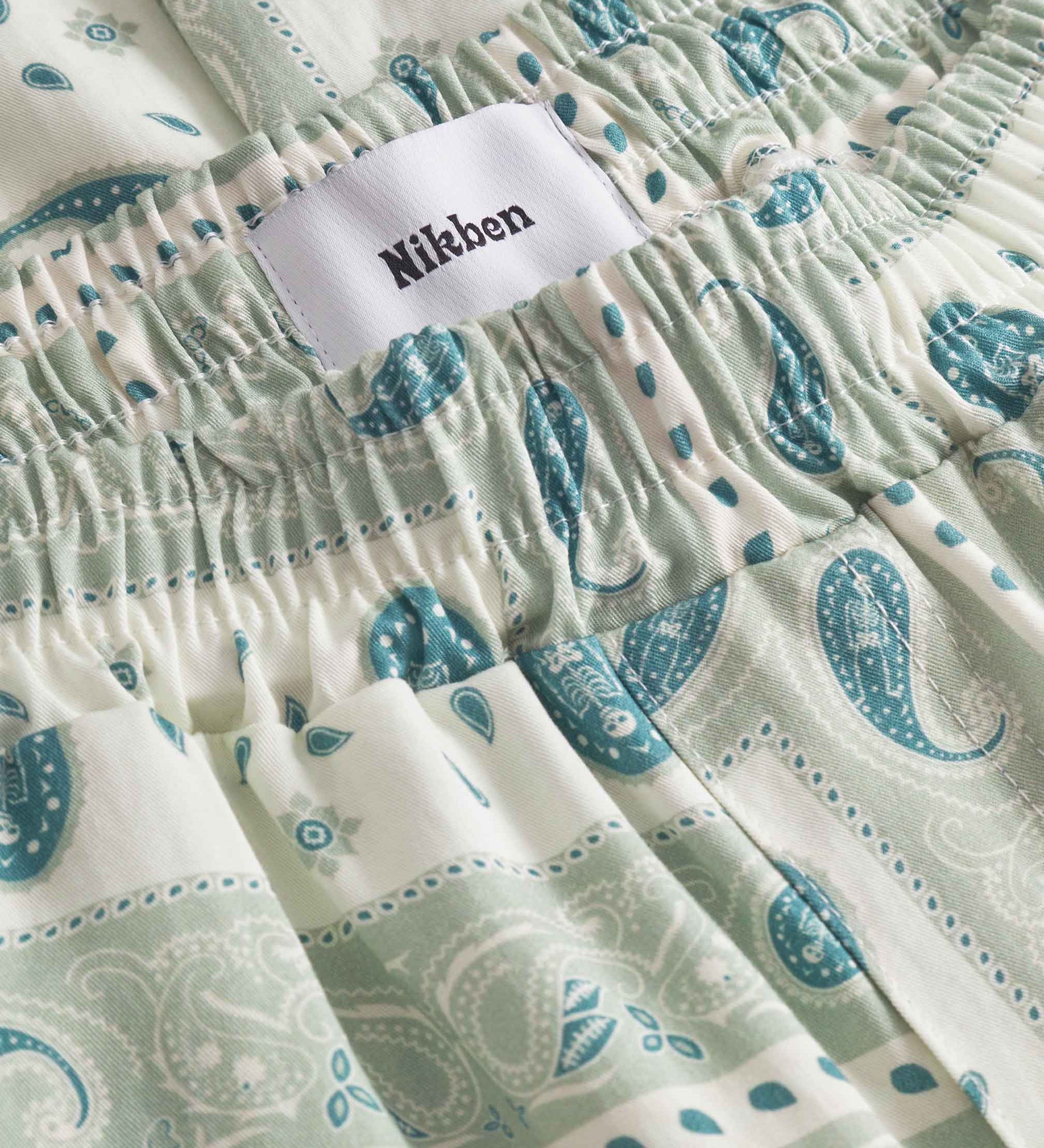 Close up of waist on a pair of vintage pale yellow paisley pattern long pants