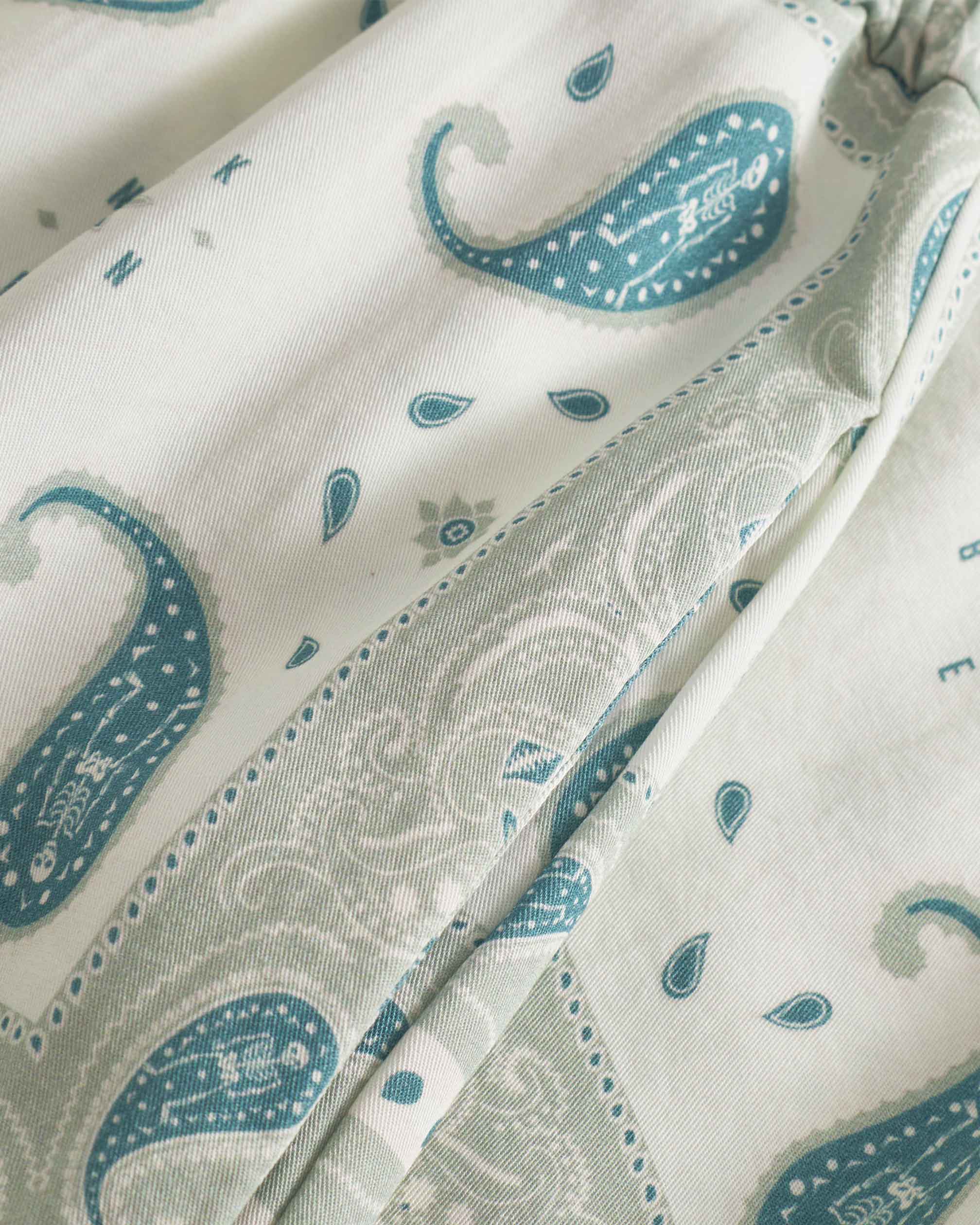 close up on pocket on vintage pale yellow paisley pattern long pants