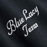 Close up of embroidered text 'Blue Lacy Texas' on  black t-shirt