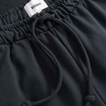 Black pants with a drawstring and visible brand label