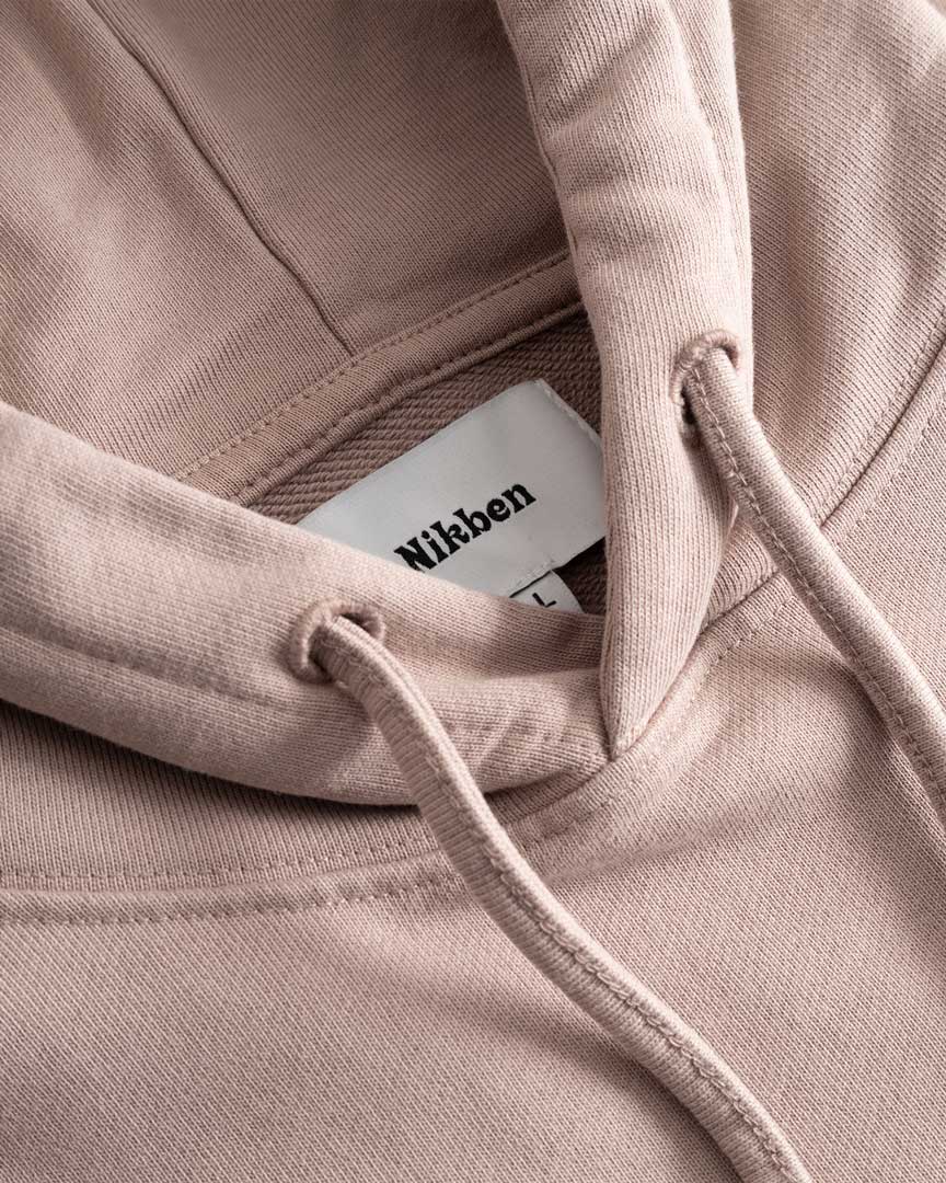 Closeup view of Nikben necklabel on brown hoodie