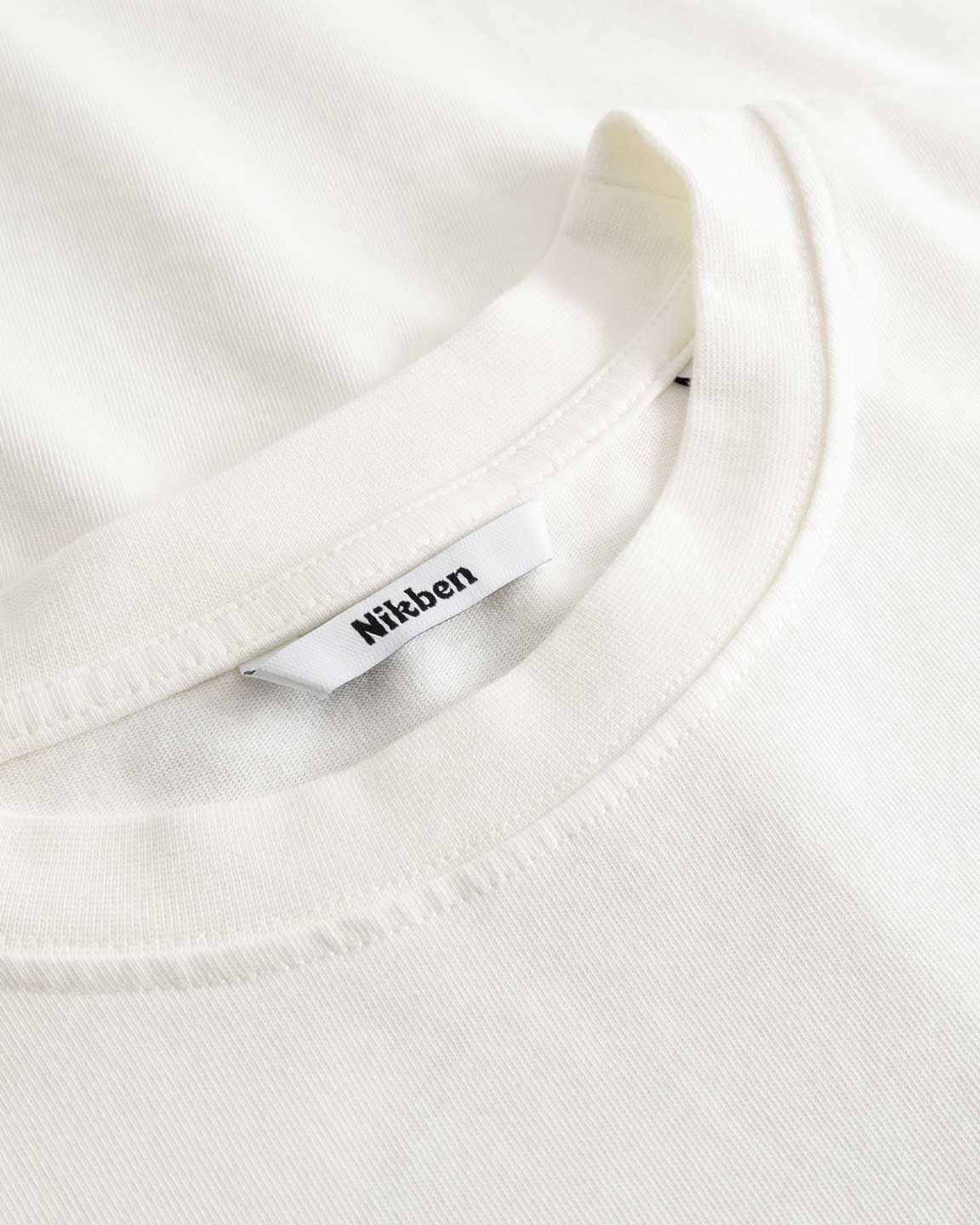 Closeup view of Nikben necklabel on white T-shirt
