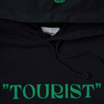 Closeup view of green print on hood and middle chest on black hoodie