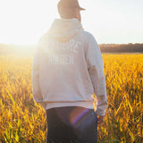 Model wearing beige hoody, with printed logo on the back