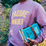 Model wearing purple sweatshirt with yellow front text.