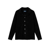 A long sleeve black terry towelling shirt with pearl buttons