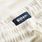 Close up on elastic waistband on off white low cut shorts in terry toweling fabric