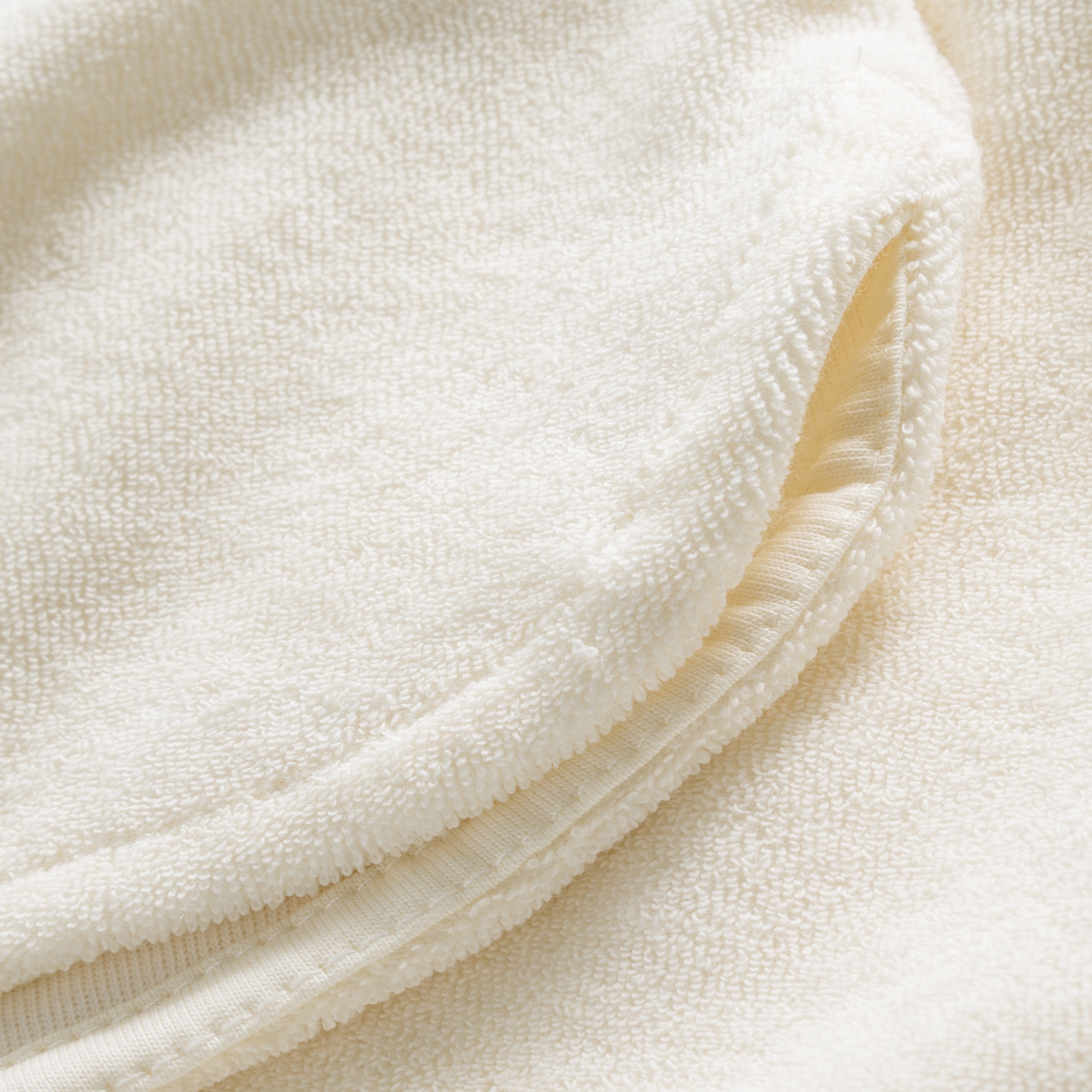 Close up on leg waistband on off white low cut shorts in terry toweling fabric