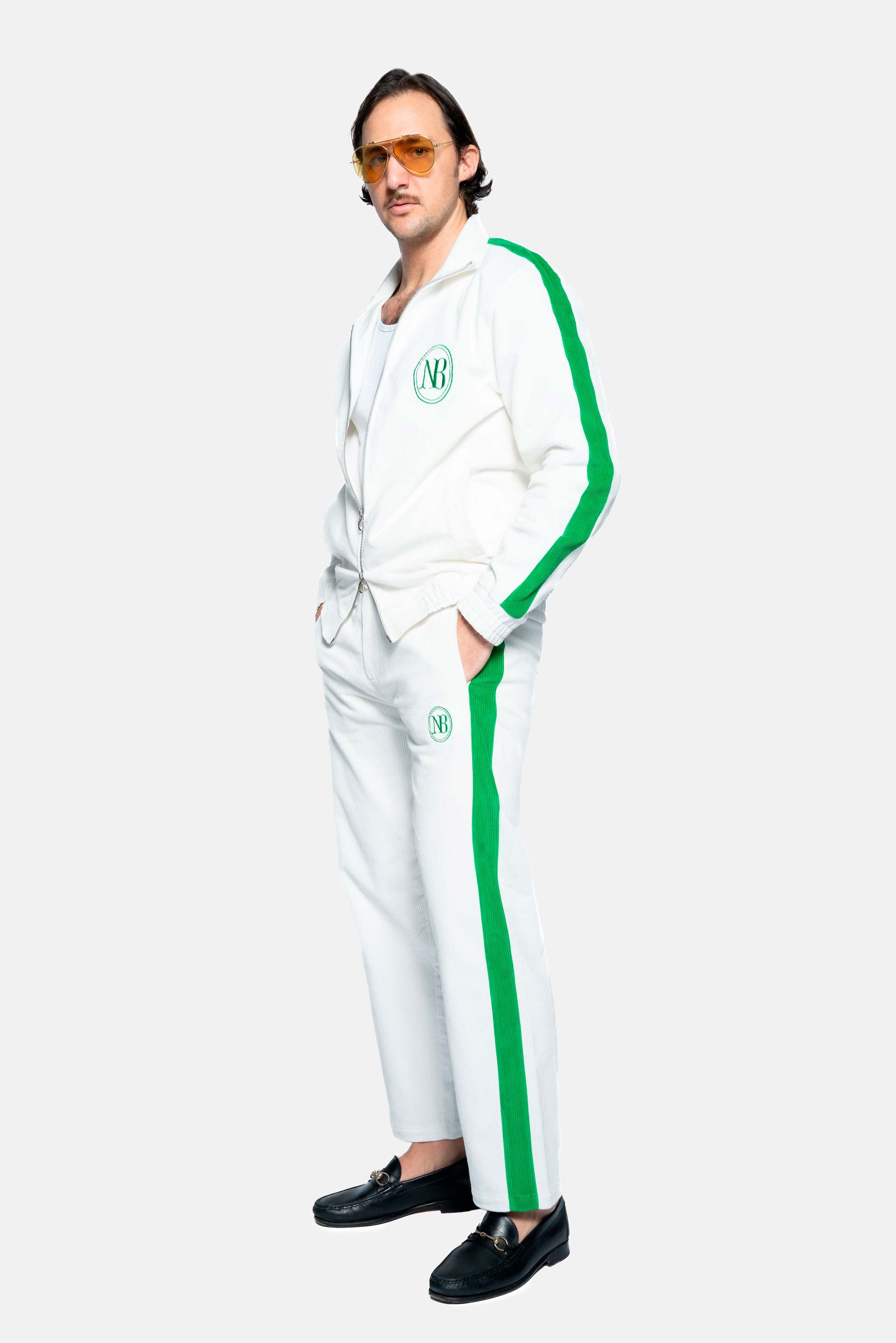 male model wearing white and green corduroy track suit pants with NB embroidery