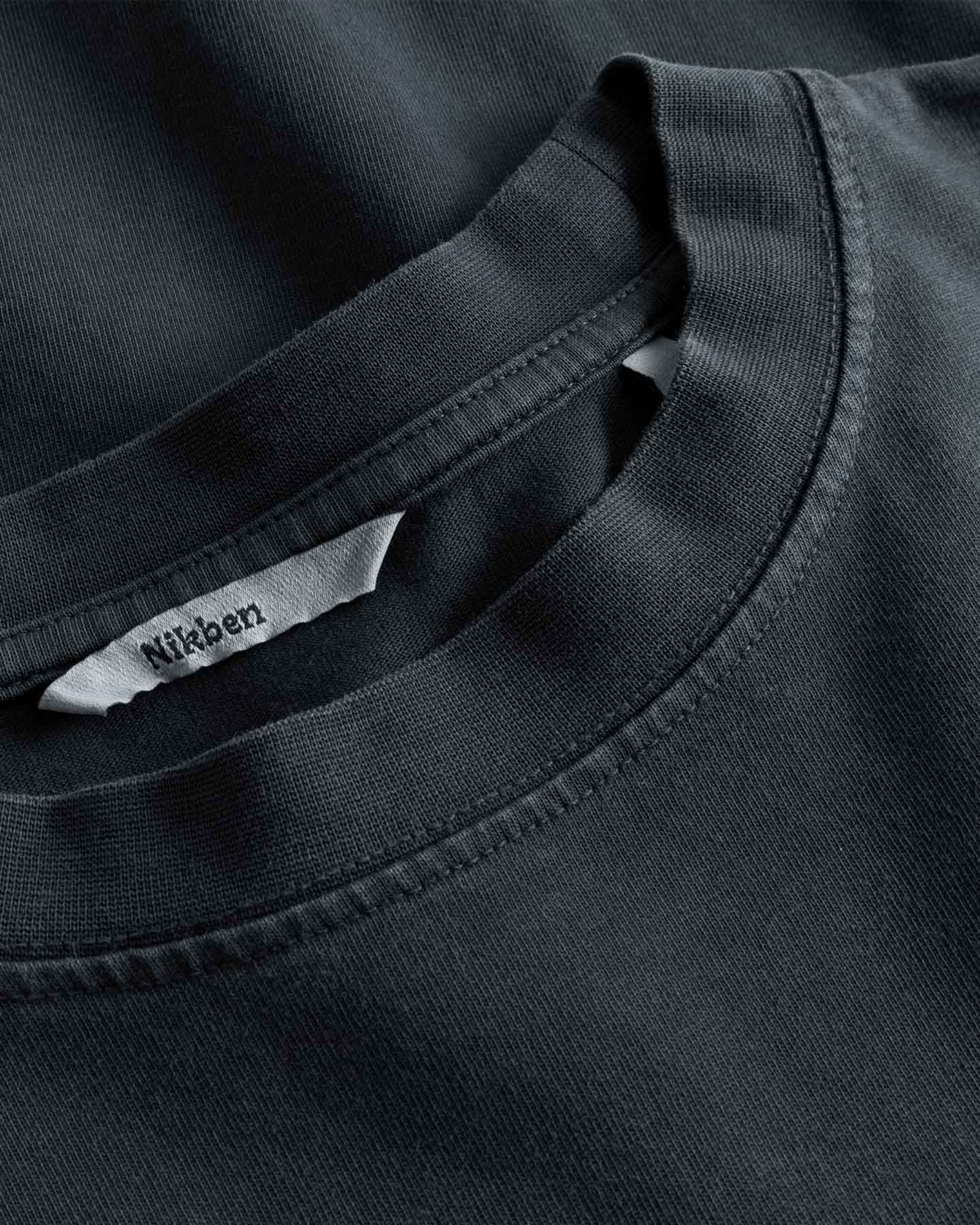 Close-up of round neck and stitching on washed black T-shirt