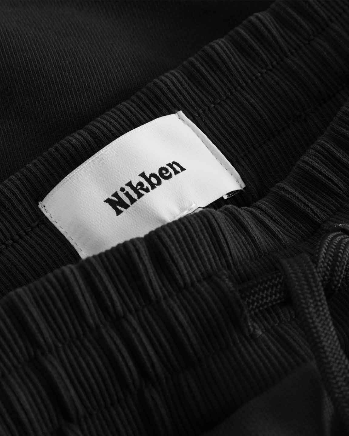 Close up of ribbed waistband and drawstrings on a pair of black sweatshorts