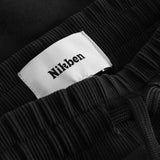 Close up of ribbed waistband and drawstrings on a pair of black sweatshorts