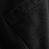 Close up of back pocket and tonal stitchings on a pair of black sweatshorts