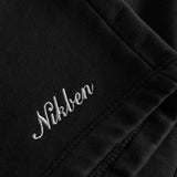 Close up on embroidered script logo on front leg of black washed sweatshorts