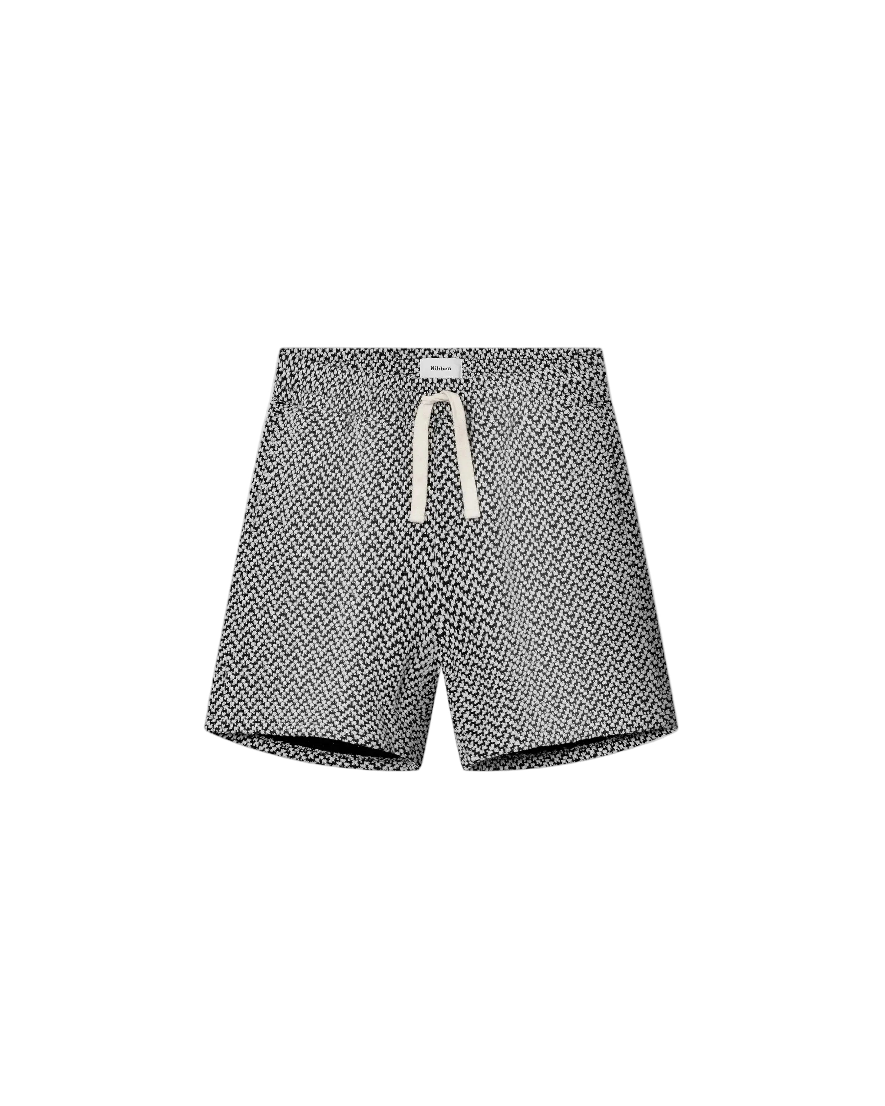 A pair of mid-length black shorts with a geometric jacquard texture, featuring a relaxed fit and a drawstring waistband.