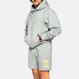 Male model wearing grey sweat shorts with drawstrings and yellow Nikben Sunshine Club print