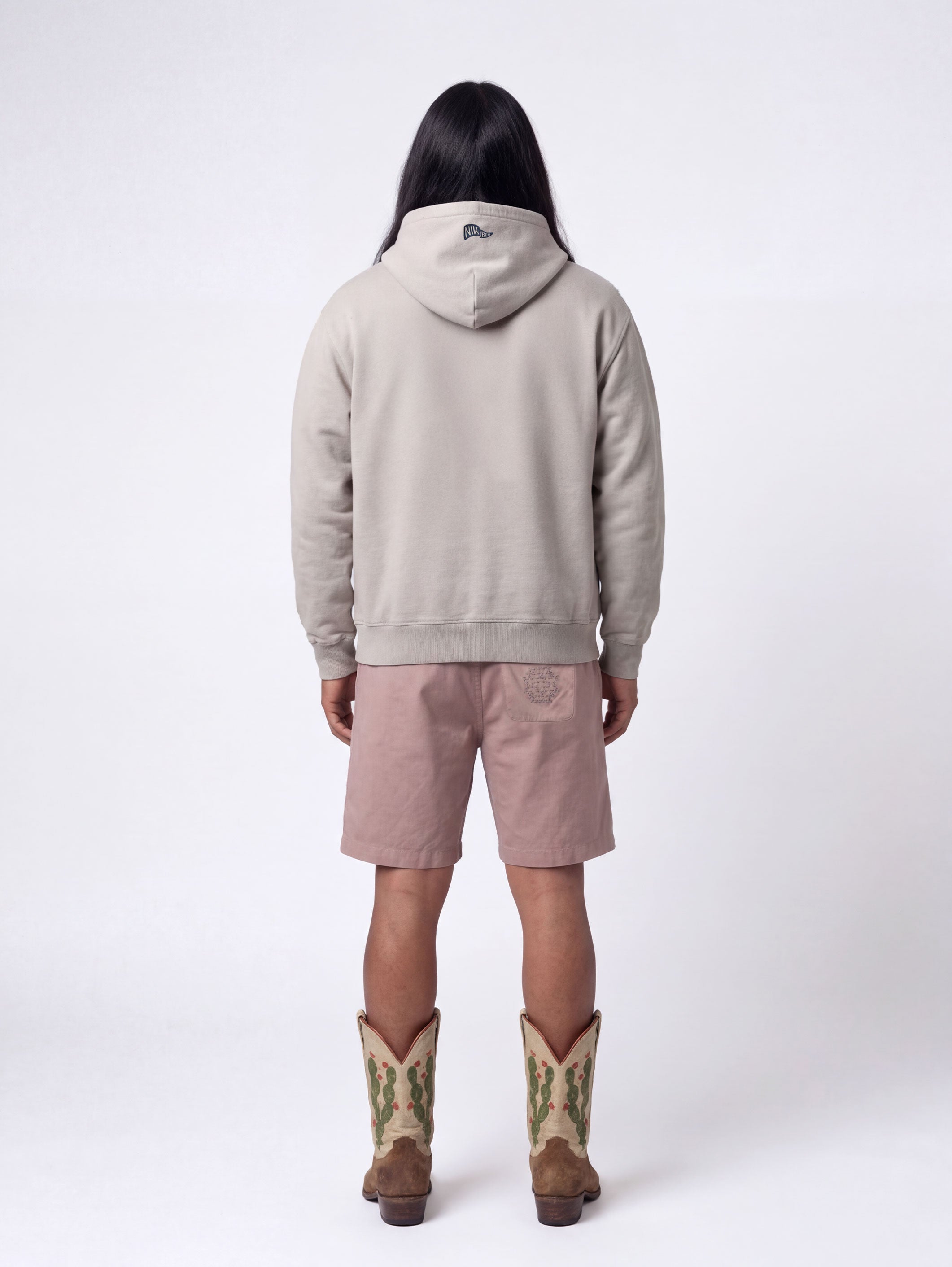 Back of male model wearing grey hoodie with blue flag print on the hood