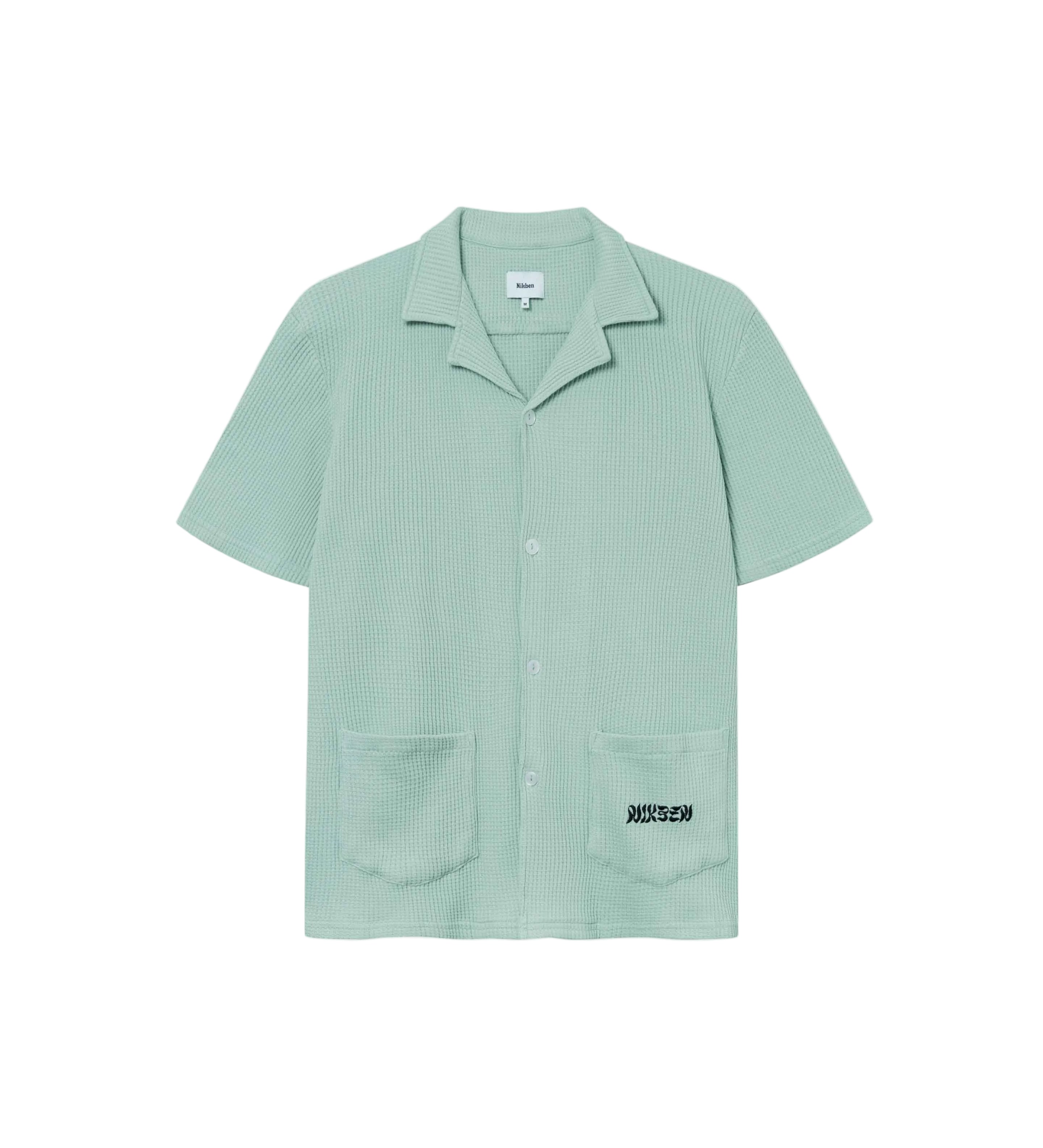 Mint green waffle-patterned short-sleeved shirt with two front pockets, featuring a stitched black Nikben logo on the left pocket and button closure.