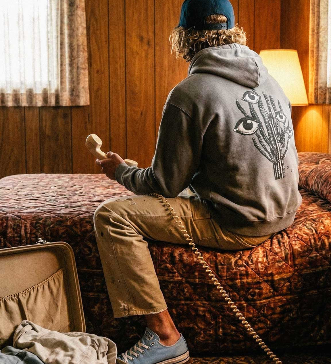 Back of male model wearing grey hoodie with black and white cactus print on the back