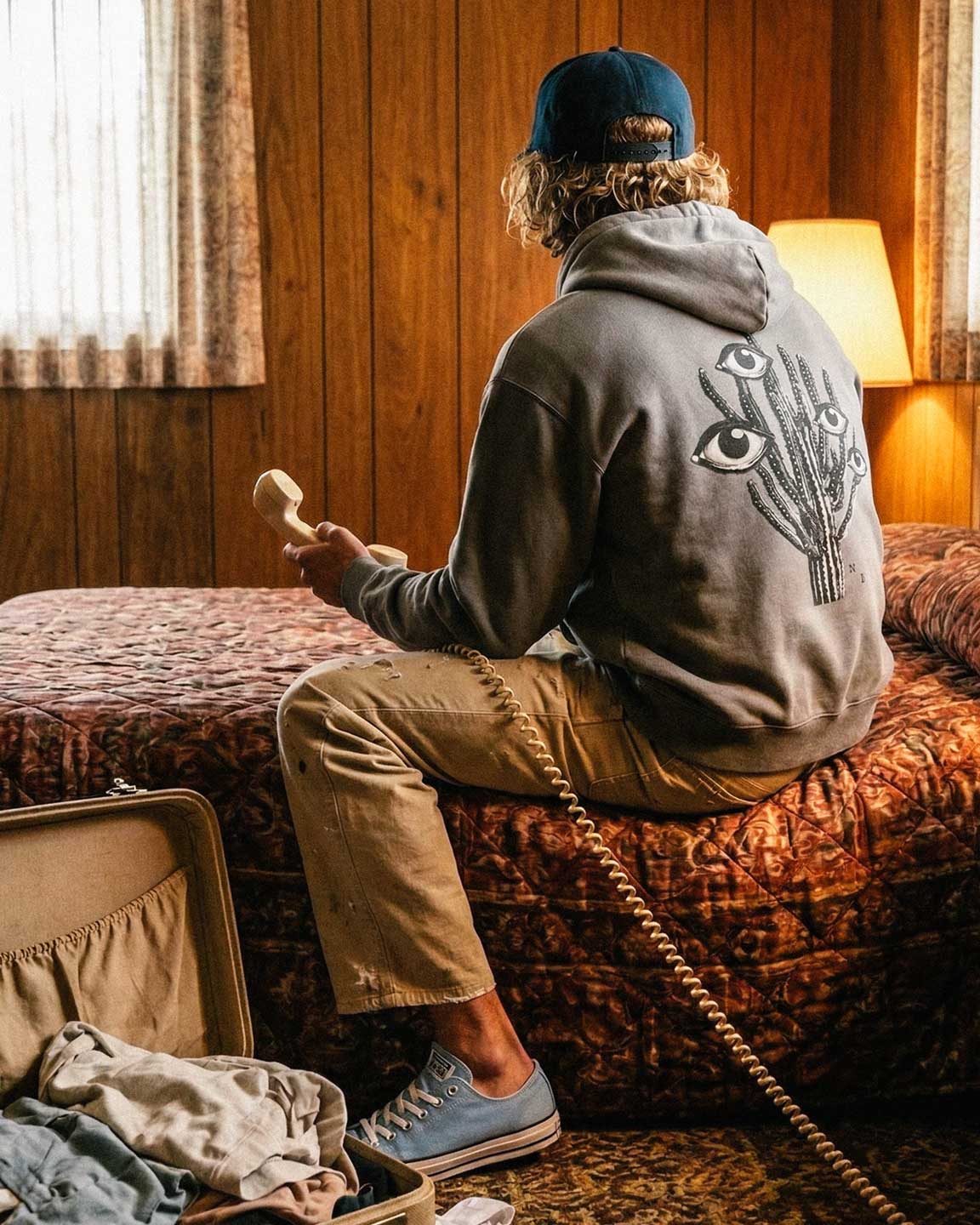 Back of male model wearing grey hoodie with black and white cactus print on the back