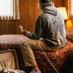 Back of male model wearing grey hoodie with black and white cactus print on the back