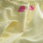 Side pocket on yellow kids swim trunks with pink dots