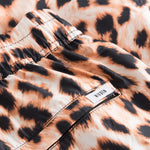 Logo on leopard printed swim trunks