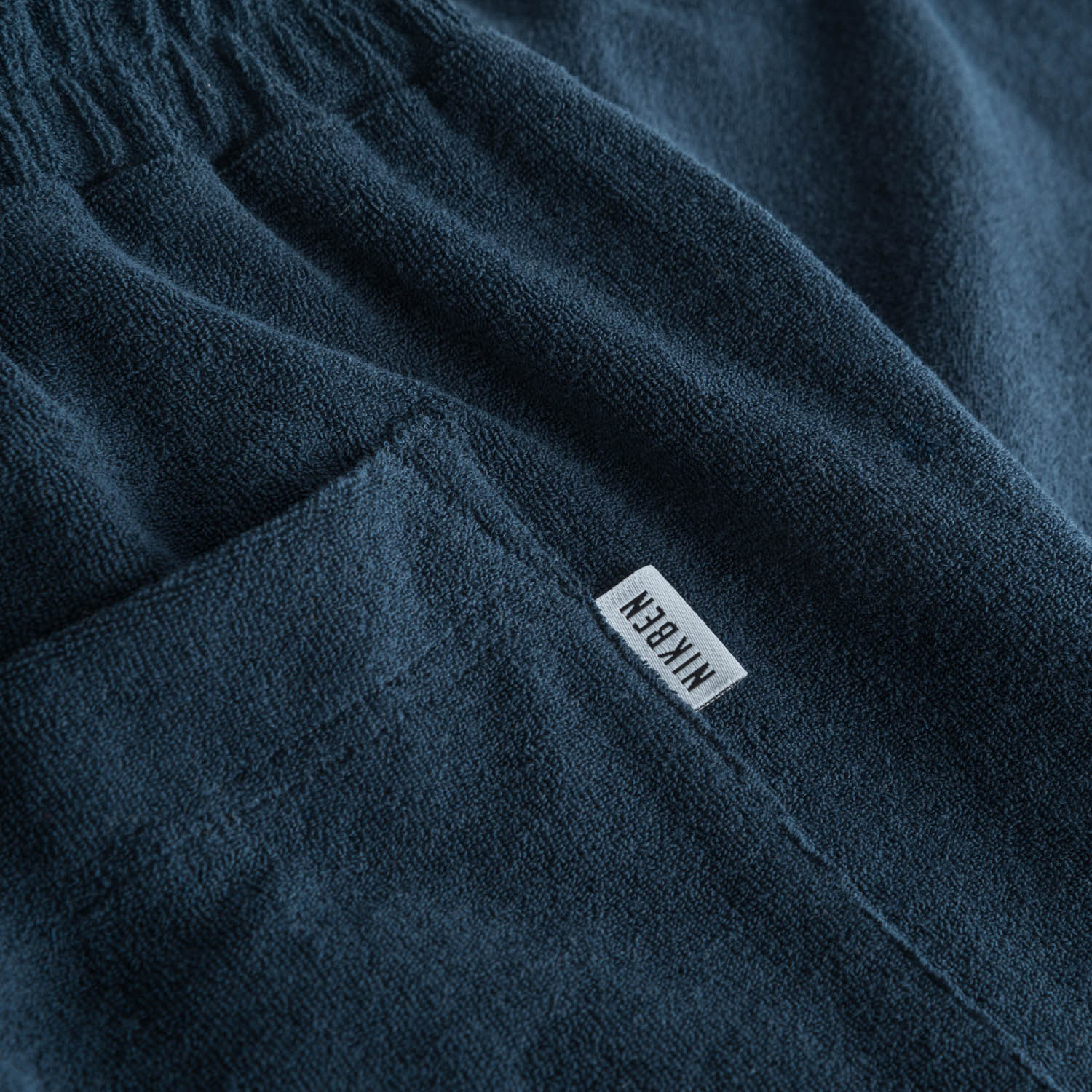 Logo on back pocket on navy blue terry towelling shorts