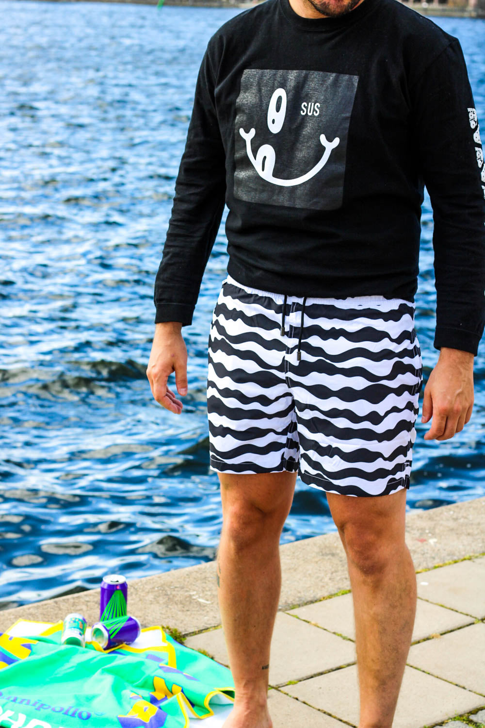 Model wearing black/white mid length swim trunks