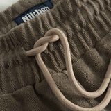 Close up on drawstring on brown and white low cut shorts in terry toweling fabric