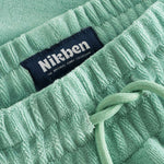 Close up on drawstring on grey-green low cut shorts in terry toweling fabric