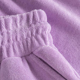 Close up on elastic waistband on purple low cut shorts in terry toweling fabric