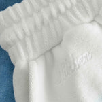 Close up on embroidered logo on white and sky blue low cut shorts in terry toweling fabric