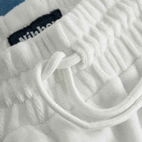 Close up on drawstring on white and sky blue low cut shorts in terry toweling fabric